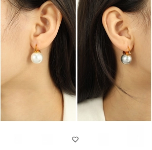 Détail de grandes boucles d'oreilles perles blanches et gris soie avec crochets dorés