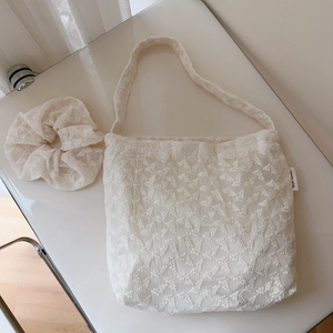 Detail of cream lace tote bag with matching scrunchie featuring vintage floral embroidery