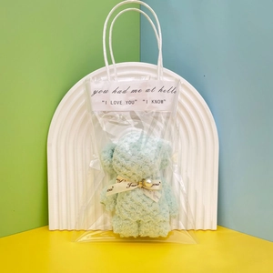 Detail of light blue coral fleece bear towel in clear gift bag with bow decoration