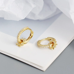 Close-up of gold s925 silver hoop earrings with rotating star pendants and white zircons