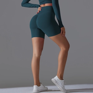 Detailed close-up of dark green seamless high-waist yoga shorts with peach lift effect