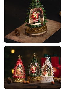 Close-up of glowing Christmas tree snow globes with Santa, reindeer and snowman figures