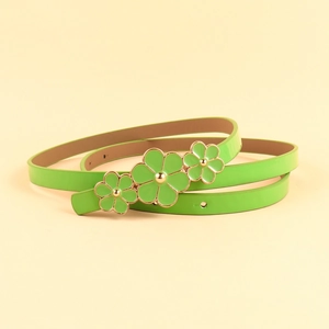 Detail view of a glossy light green skinny belt featuring golden floral buckle accents