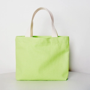 Detail shot of a light green canvas tote bag with sturdy beige woven handles