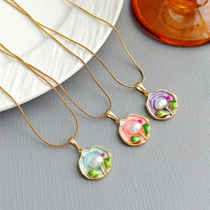 Detailed macro of vintage rose pendants with enamel colors and central pearl inlays