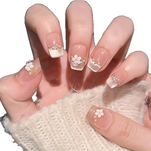 Elegant nude French press-on nails with white floral charms and pearl accents