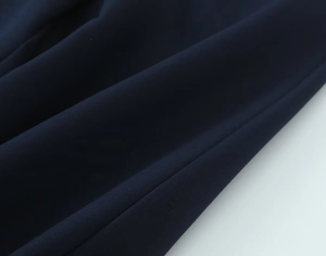 Vue détaillée de la texture du tissu bleu marine avec drapé élégant et finition lisse