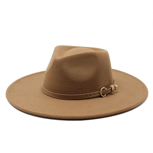 Détail d'un chapeau fedora en laine marron avec sangle en cuir et boucle dorée sur fond blanc