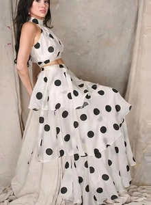 Detail von weißem Polka-Dot-Neckholder-Top und gestuftem Maxirock mit Rüschen