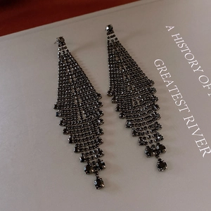 Detail of luxury long tassel earrings with black rhinestones and crystal drop pendants