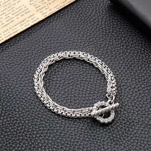 Détail du bracelet chaîne double épaisseur argenté avec fermoir OT sur cuir noir