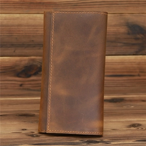 Vintage crazy horse leather long wallet for men with rustic stitching on wood background