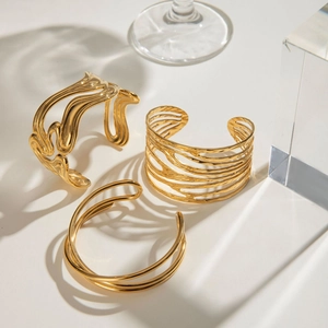 Three gold irregular hollow multilayer stainless steel open cuffs with fluid line design