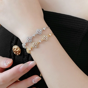 Detailed macro view of gold and silver four-leaf clover bracelets with sparkling zircon