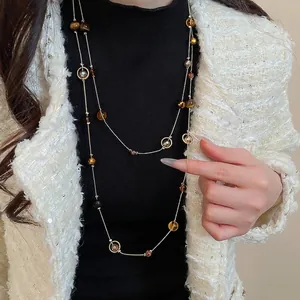 Mehrlagige Boho-Pulloverkette mit Steinperlen und Goldkette am Modell getragen