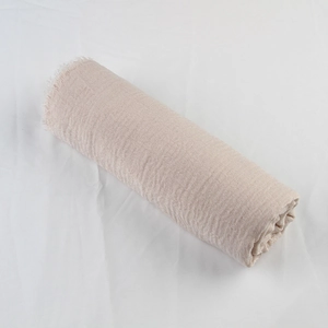 Detail of beige cotton linen scarf featuring natural crinkle texture and frayed raw edges
