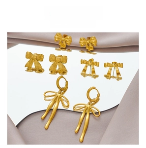Detailed view of elegant gold bow earrings in stud and hoop styles with matte finish