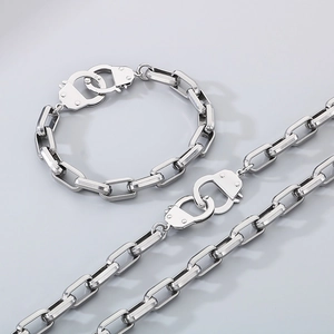 Detailed view of silver stainless steel chain necklace and bracelet with shackle design