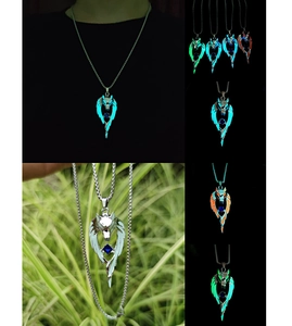 Detailed view of luminous wolf head pendant with wings and glowing center gemstone