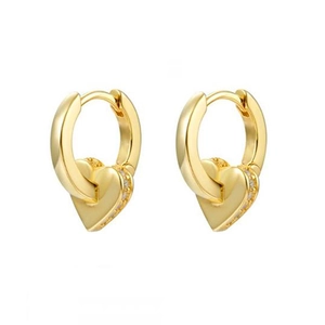 Detail of gold heart earrings with zircon inlay along the side on a minimalist base