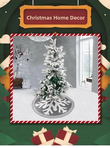Detail of gray knitted Christmas tree skirt featuring large white snowflake patterns