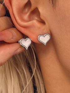 Macro shot of silver heart stud earrings featuring white mother-of-pearl and perlee beads