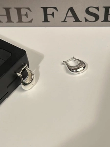 Detailed view of minimalist U-shaped silver tulip earrings with polished finish