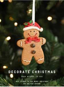 Macro detail of gingerbread man Christmas ornament hanging on a bokeh pine tree branch