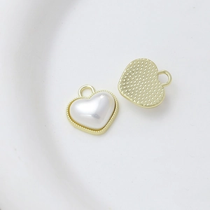 Detail showing heart pearl charm with gold border for jewelry making and DIY crafts