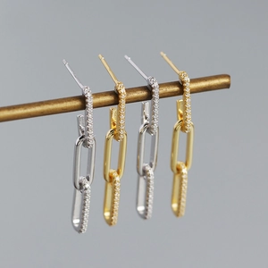 Detailed view of silver and gold double-chain earrings featuring cubic zirconia paving