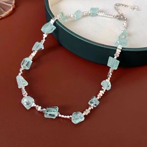 Dettaglio della collana con pietre verde menta, perle argentate e catena regolabile