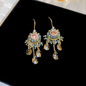 Detail of bohemian floral drop earrings with blue beads and amber crystal tassels