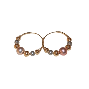 Elegant twisted hoop earrings featuring alternating gold, silver and pearl beads on metal