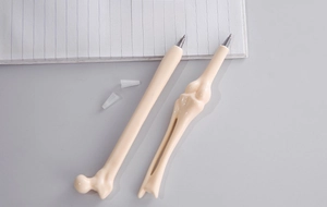 Detailed view of bone-shaped ballpoint pens with black and blue ink on paper
