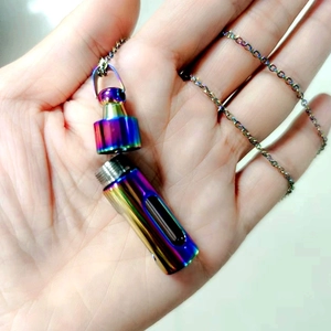 Macro detail of rainbow stainless steel capsule pendant with threaded screw opening