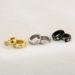 Dettaglio ravvicinato di orecchini a cerchio oro, argento e nero con pietre di zircone