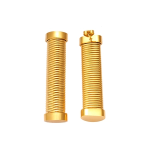 Macro shot of gold cylinder earrings with spiral texture and modern industrial design
