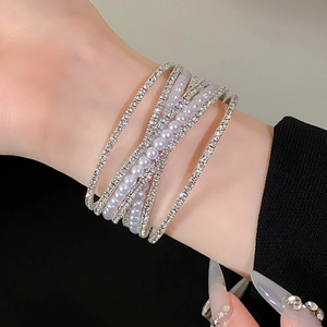 Detailweergave van de zilverkleurige strass kettingen en lavendel parels armband