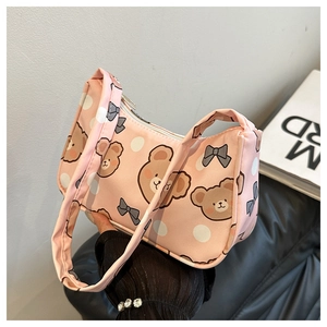Detailed view of pink shoulder bag featuring cartoon bear and grey bow patterns