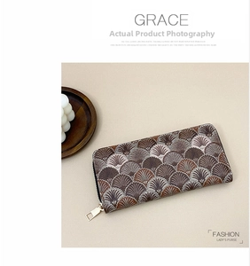 Close-up of shell-shaped embroidery and gold zipper on long women's wallet