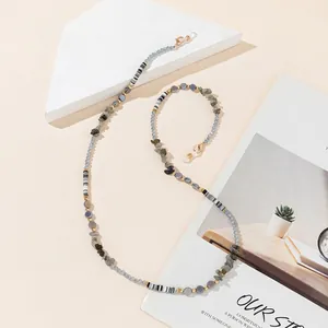 Detail of eyewear chain with blue beads, grey stones, and golden lobster clasps