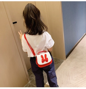Detail of red and white girl's crossbody bag featuring bunny ears and a bow design