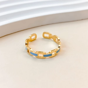 Close-up of gold chain-style ring with light blue enamel finish on minimalist wave decor