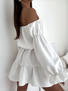 Détail d'une mini robe blanche à épaules dénudées avec manches lampion et ourlet à volants