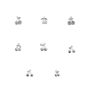 Macro detail of eight diverse silver cherry pendants with textured and hollow designs