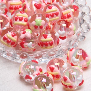 DIY cartoon beads with hand-painted heart and star patterns in a glass bowl