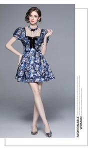 Detail of blue floral print dress featuring lace collar and black velvet bow accent