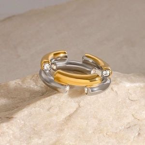 Detail of two-tone stainless steel ring with zircons on natural light stone base
