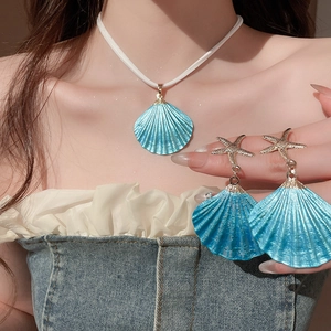 Close-up of blue shell pendant necklace and starfish earrings set on a model