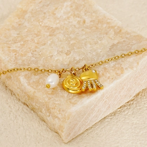 Bohemian gold octopus necklace with pearl pendant on a natural stone background